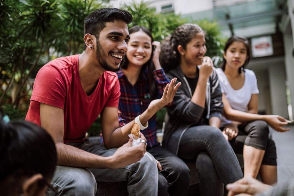 Young adults sitting on a campus bench